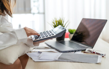 Human use calculator and calculate bills and paying bill, credit card, tax and vat, payment, concept of money management and business report with financial documents, financial accounting concept