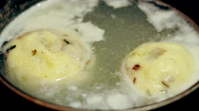Close up to a couple of Kn&ouml;del or german potato dumpling boiling in a pot, authentic traditional local food from Germany