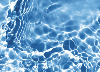 Abstract blurred shades of blue water background. Light and shadow ripples or splashes surface of water texture. Water waves and bubbles with shining and reflection pattern photography for​ artwork.