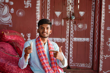 indian farmer holding Ginger and pointing