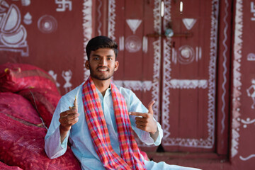 indian farmer holding Ginger and pointing