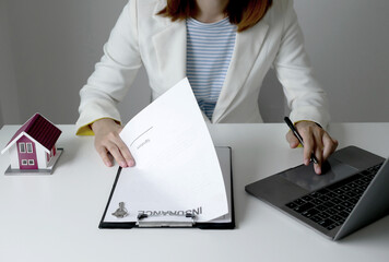 Businesswoman real estate agent signs documents and gives home insurance advice Create a home...