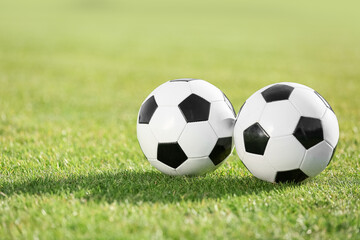 Soccer balls on green stadium grass, closeup
