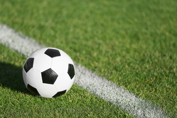 Soccer ball on green stadium grass, closeup