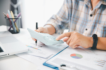 Accountant working on desk using calculator for calculate finance report in office. business...