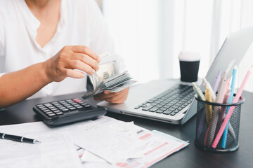 Using calculating machine, household carefully manages each bill and expense to plan financial...