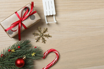 Christmas decorations and gifts on light wood background