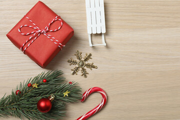 Christmas decorations and gifts on light wood background