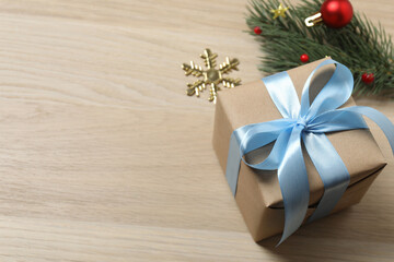 Christmas decorations and gifts on light wood background