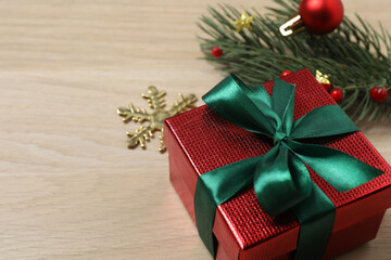Christmas decorations and gifts on light wood background
