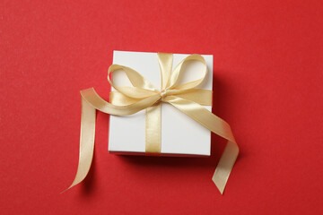 Top view of gift box trinket, fir branch, on red background, space for text