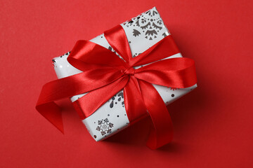 Top view of gift box trinket, fir branch, on red background, space for text