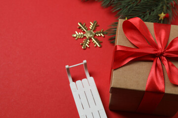 Top view of gift box trinket, fir branch, on red background, space for text