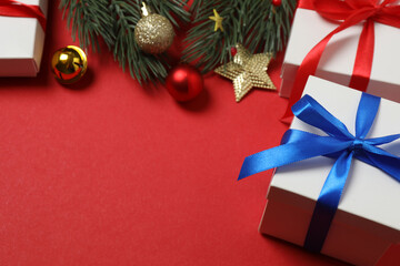 Top view of gift box trinket, fir branch, on red background, space for text