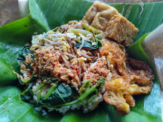 Nasi pecel or sego pecel is a typical Javanese Indonesian rice dish served with pecel sauce, which can be added with vegetables, eggs, tempeh and other side dishes.