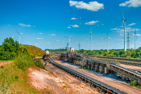 Opencast mine Garzweiler II with conveyor belts and wind turbines in the background