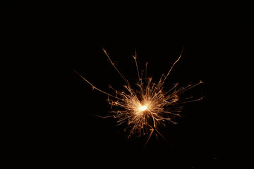 Burning sparks flying. Beautiful flames. Fiery orange glowing flying away particles on black...