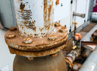 close-up of a rusted industrial pipeline flange with corroded bolts and a weathered metal surface