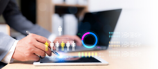 Businessman using stylus on tablet with digital HR management interface, employee structure chart, and team analytics dashboard. Concept of workforce planning and data-driven HR.