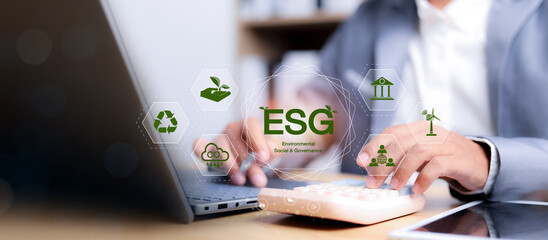 Businessman using laptop and calculator with ESG icons representing environmental, social, and governance principles. Concept of sustainable finance and corporate responsibility.