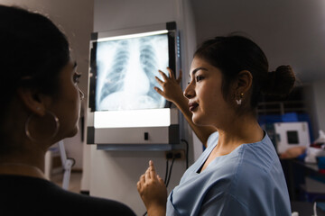 Nurse explaining X-ray results to a patient in a hospital setting
