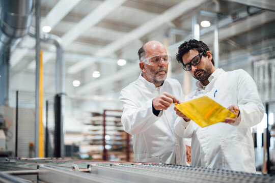 Engineers discussing product development in a factory setting