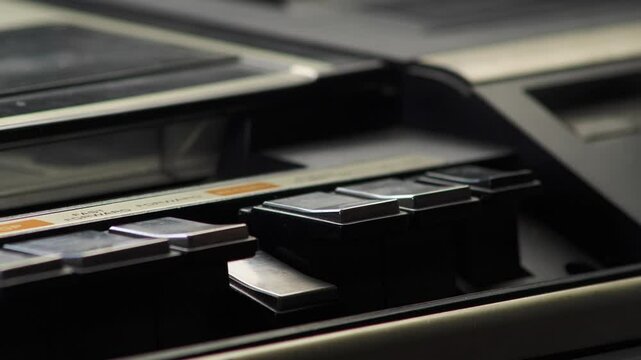 Finger activates rewind Button on Retro VHS Video Cassette Recorder