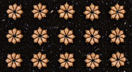 Golden Acorns Arranged in Flower Patterns on Black Soil Background. NATURAL AUTUMN Deceration and Seasonal Craft Concept