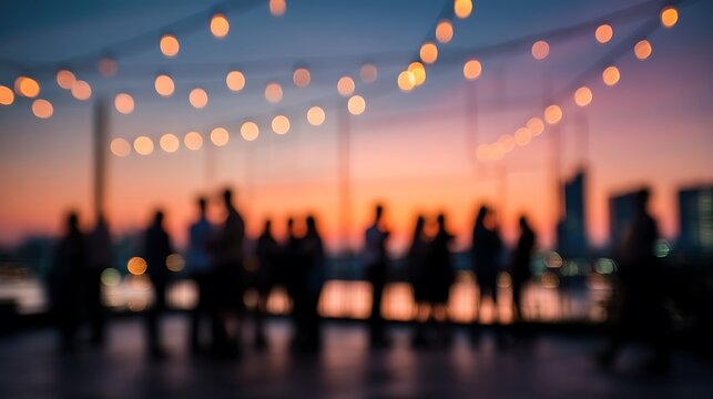 Rooftop party with string lights and silhouettes of people against a colorful sunset sky