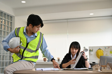 Professional collaboration between architect and engineer discussing detailed design plans and...