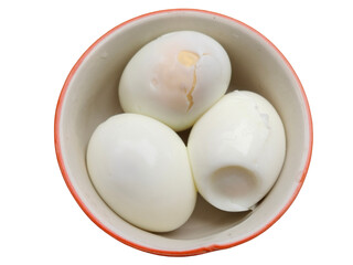 Three boiled eggs, one cracked, placed inside a round bowl.