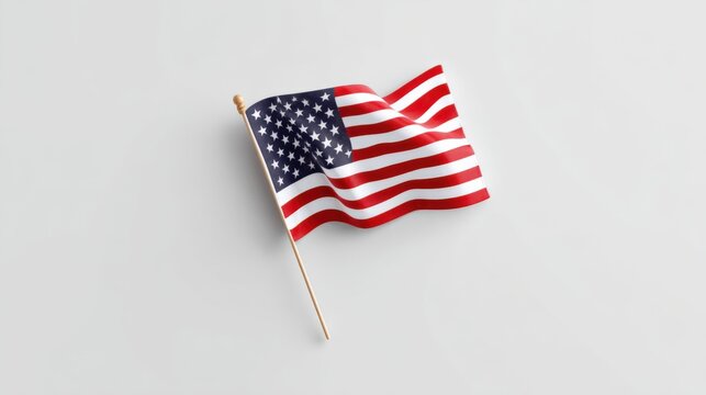 American flag waving on a wooden pole with a plain light gray background.