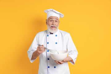 Professional pastry chef with whisk and bowl on orange background