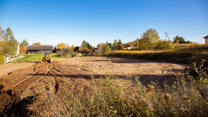 Yellow bulldozer at a construction site. Big wheel excavator leveling and clearing the land plot...