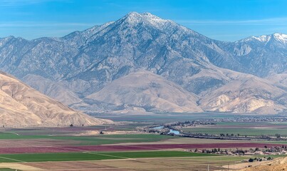 Mountain peak with snow, agricultural valley below