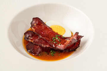 Barbecue pork slices with hard-boiled egg in a savory brown sauce