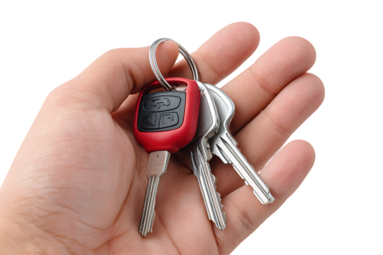 Hand holding a bunch of car keys with a red fob isolated on transparent background