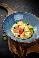 Creamy seafood risotto with shrimp, mussels, and calamari on a dark background. Elegant Italian rice dish.