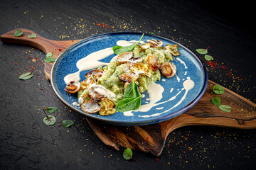 Italian pasta with zucchini, parmesan, spinach, and mussels on a dark background. Fresh and elegant seafood dish.