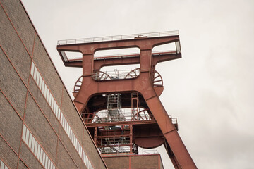 Close up and low angle view of Zollverein Coal Mine Industrial Complex tower on an overcast day,...