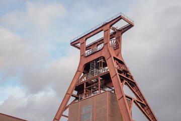 Low angle view of Zollverein Coal Mine Industrial Complex tower with cloudy blue sky background,...