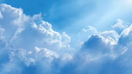 Naklejka premium Bright blue sky with fluffy white clouds and radiant sunlight shining through.