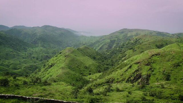 Aerial view of Rayta Hills in Udaipur, Rajasthan, India. Lush green mountains under a cloudy sky during the monsoon season, creating a perfect travel and holiday backdrop.