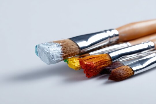 Artist is paintbrushes and palette knife on white backdrop