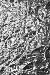 Wrinkled aluminum foil texture background with reflective silver surface, perfect for material,...