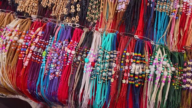 A vibrant display of assorted handmade beaded bracelets, featuring a variety of colors, patterns, and textures. These intricately woven accessories showcase a fusion of cultural craftsmanship