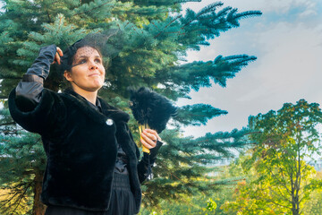 A young women in vintage clothes on a walk in the park. 