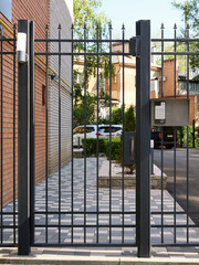 Closed courtyard of a residential building with an electronic code lock on the fence.