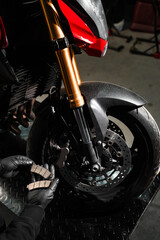 Front Brake Pad Replacement on Red Sport Motorcycle. Front brake pads are inspected and swapped out...