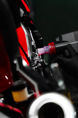 Precision oil fill operation on a red sportbike to ensure proper engine lubrication. Motorcycle Oil...